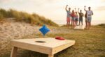 Cornhole loogihetk rannapeol - kott lendamas laua augu poole